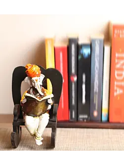 Orange Polyresin Lord Ganesha Idol reading Book on Wooden Chair